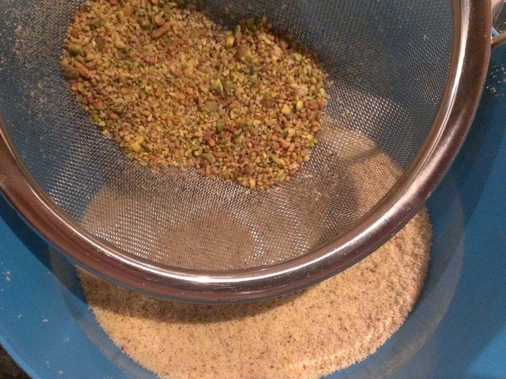 Press the ground pistachios through a sieve to separate the nubbly from the smooth 